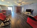 Open living room with hardwood floors, an entertainment cabinet, and a bar area at 2022 Peaceful Palm St, Ruskin, FL 33570