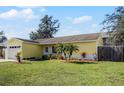 Bright yellow house with a lush green lawn and palm trees at 13910 Fullerton Dr, Tampa, FL 33625