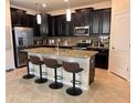 Modern kitchen with island, granite countertops, and dark cabinets at 13642 Newport Shores Dr, Hudson, FL 34669