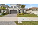 Two-story house with gray siding, stone accents, and a 3-car garage at 3135 Great Banyan Way, Wesley Chapel, FL 33543