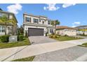 Two-story house with gray siding, stone accents, and a 3-car garage at 3135 Great Banyan Way, Wesley Chapel, FL 33543