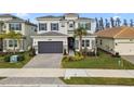 Two-story house with gray siding, stone accents, and a 3-car garage at 3135 Great Banyan Way, Wesley Chapel, FL 33543