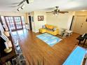 Bright living room featuring a yellow sofa, wood floors, and a ceiling fan at 802 Gateway Ln, Tampa, FL 33613