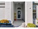 Front entry with door, brick columns, and small plants at 18004 Tarrington Pl, Hudson, FL 34667