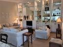 Bright living room showcasing a comfy seating arrangement and built-in shelving at 7580 Camminare Dr, Sarasota, FL 34238