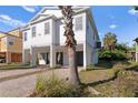 Two-story house with white exterior, palm trees, and a paved driveway at 8235 Gulf Way, Hudson, FL 34667