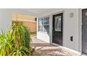 Front entrance with black door, brick walkway, and lush greenery at 8235 Gulf Way, Hudson, FL 34667