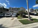 Exterior view of townhouses with parking in front and landscaping at 1702 Arabian Ln, Palm Harbor, FL 34685