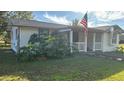 White single story home with red trim and American flag at 2205 Mcgee Rd, Plant City, FL 33565