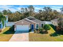 One-story house with a white garage door and blue front door, surrounded by trees at 2729 Walden Woods Dr, Plant City, FL 33566