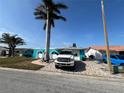 Teal house with palm trees, a paved driveway, and a white truck parked in front at 4903 Shell Stream Blvd, New Port Richey, FL 34652