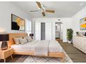 Bright bedroom with light wood platform bed, ceiling fan, and en-suite bathroom at 7326 Shepherd St, Sarasota, FL 34243