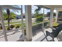 Relaxing screened porch with wicker furniture, overlooking a residential street at 1835 Scarlett Ave, North Port, FL 34289