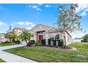 One-story home with red door, landscaping, and driveway at 30350 Grymes Dr, Wesley Chapel, FL 33545