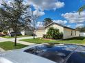 Exterior view of a home with a well-maintained lawn and palm trees at 39567 Dawson Chase Dr, Zephyrhills, FL 33540