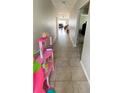 Long hallway with tile flooring leading into the living room at 39567 Dawson Chase Dr, Zephyrhills, FL 33540