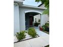 Arched front porch with seating and decorative plants near the home's entrance at 7111 Amelia Cove Ct, Sun City Center, FL 33573