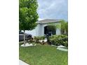 Landscaped front yard with colorful plants, white rock mulch, and a young tree at 7111 Amelia Cove Ct, Sun City Center, FL 33573