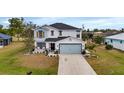 Two-story house with light gray siding, gray roof, and a light blue garage door at 25393 Durango Ct, Punta Gorda, FL 33955
