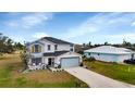 Two-story house with light-colored siding, gray roof, and a landscaped front yard at 25393 Durango Ct, Punta Gorda, FL 33955