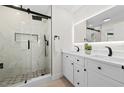Modern bathroom with dual vanity, backlit mirror and walk-in shower with beautiful tile surround at 105 12Th Sw St, Ruskin, FL 33570