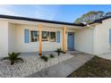 Bright front entrance featuring natural wood pillars and light blue door and shutters at 105 12Th Sw St, Ruskin, FL 33570