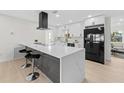 Modern kitchen with large quartz countertop island, sleek black appliances, and bar stool seating at 105 12Th Sw St, Ruskin, FL 33570