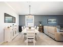 Dining area with a modern light fixture, neutral decor, and views into the living space at 11400 Burgundy Dr, Venice, FL 34293