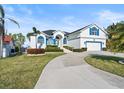 Charming two-story home with manicured lawn, circular driveway, and bright white exterior paint at 6354 Cocoa Ln, Apollo Beach, FL 33572