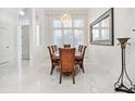 Formal dining room with marble floors, a modern chandelier, and bright light at 818 Golf Island Dr, Apollo Beach, FL 33572