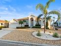 Lush landscaping highlights this bright home featuring a manicured lawn and circular driveway at 818 Golf Island Dr, Apollo Beach, FL 33572