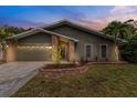 Inviting home exterior showcasing a well-manicured lawn, brick accents, and a two-car garage at 289 Whisper Lake Rd, Palm Harbor, FL 34683