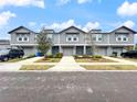 Attractive townhome complex with gray siding, neat landscaping, and private garages for each unit at 2764 Emory Sound Pl, Brandon, FL 33510