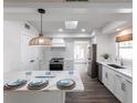 Bright and airy kitchen features white cabinets, an island, and stainless steel appliances at 5239 Winding Way, Sarasota, FL 34242