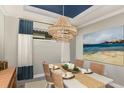 Formal dining room featuring stylish chandelier, large print wall art, and table set for four at 29537 Zupetta Ln, Wesley Chapel, FL 33545