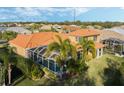 Aerial view of a well maintained property featuring a screened pool and lush green lawn with mature palms at 6977 74Th Street E Cir, Bradenton, FL 34203