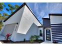 Close-up of the home's modern design, featuring a gray accent wall and stylish front door with glass panels at 4044 Simkins Ave, North Port, FL 34286