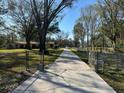 Long concrete driveway leading to a home with a fenced yard, enhancing curb appeal and access at 7306 Jones Rd, Odessa, FL 33556