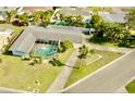 Aerial view of a home's backyard highlighting the screened-in pool and well-maintained landscaping at 10111 Yacht Club Dr, Treasure Island, FL 33706