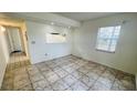 Cozy living area featuring tiled floors, a window, and a passthrough to the kitchen at 7120 Waterside Dr # 106, Tampa, FL 33617