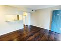 View of the living room from the entry, shows hardwood floors and passthrough to kitchen at 7113 E Bank Dr # 7113, Tampa, FL 33617