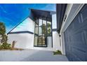 Eye-catching modern home featuring a wall of windows and stylish blue garage door at 4760 Meredith Ln, Sarasota, FL 34241