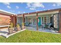 Inviting front porch with stone flooring, seating, potted plants, and a decorative pergola at 1321 Groveland Ave, Venice, FL 34285