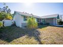 Corner view of a cozy home featuring teal window accents and a white fence at 7840 Gulf Way, Hudson, FL 34667