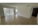 Spacious living room with tile flooring, large windows, and a sliding glass door at 7502 Needle Leaf Pl # B66, Tampa, FL 33617