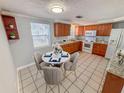 Cozy kitchen with a dining area featuring a marble table, wood cabinetry, and abundant natural light at 5125 Janice Ln, Holiday, FL 34690