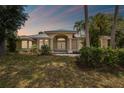 Charming home with a well-manicured lawn, mature trees, and elegant architectural details at 26058 Paysandu Dr, Punta Gorda, FL 33983