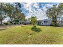 Expansive backyard featuring a lush lawn, mature trees, and a single story home at 5350 47Th N Ave, St Petersburg, FL 33709