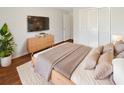 Bedroom with a large bed, wood floors, a contemporary dresser, a television, and neutral decor at 8379 Begonia St, Spring Hill, FL 34608