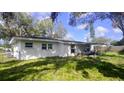 A view of the backyard, showing the house's exterior, green lawn and covered patio area at 1814 Elk Ave, Sarasota, FL 34235